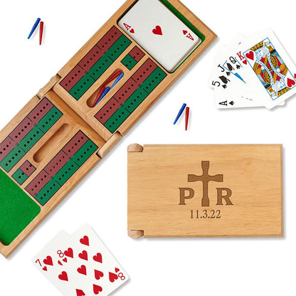 Cribbage game sets spotlighting the cribbage track, card and peg storage as well as the engraved cross design that includes a couple's initials.
