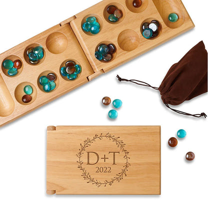 Folding mancala game engraved with a wreath that has a couple's initials inside. 
